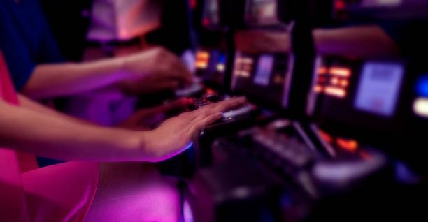 Young adult women gambling on a slot machine in a casino.