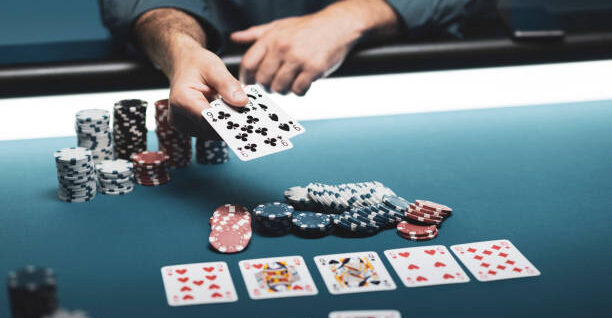 Man playing Texas Hold 'em poker at Casino, he is holding two cards
