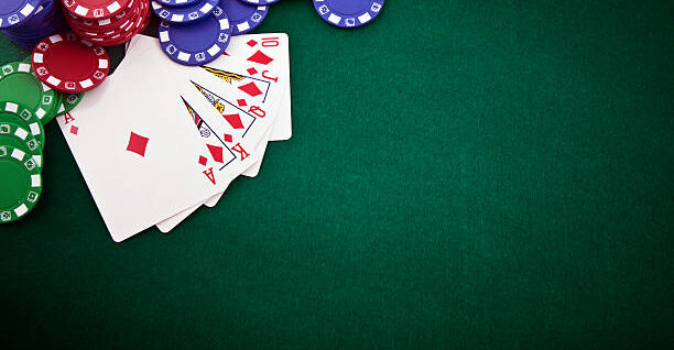 Royal flush and gambling chip on a green poker table