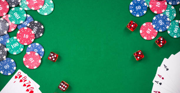 Casino games related items on green table, copy space.
