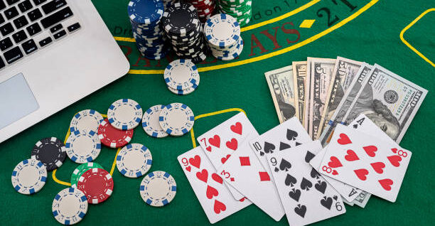 poker chips with banknotes placed on a laptop keyboard. Poker concept